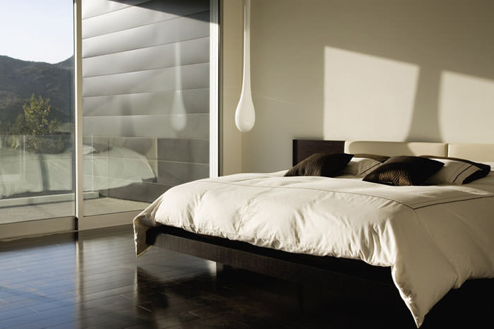 Modern bedroom with a low platform bed and natural light.