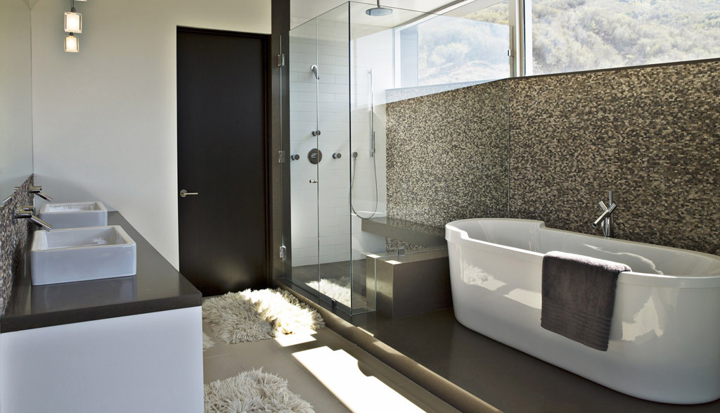Modern bathroom with a freestanding tub and mosaic tiled wall.