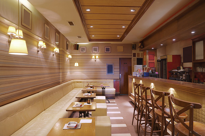 Cozy restaurant interior with cushioned seating and wooden chairs.