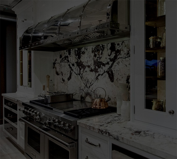 Modern kitchen with marble countertops and stainless steel appliances.