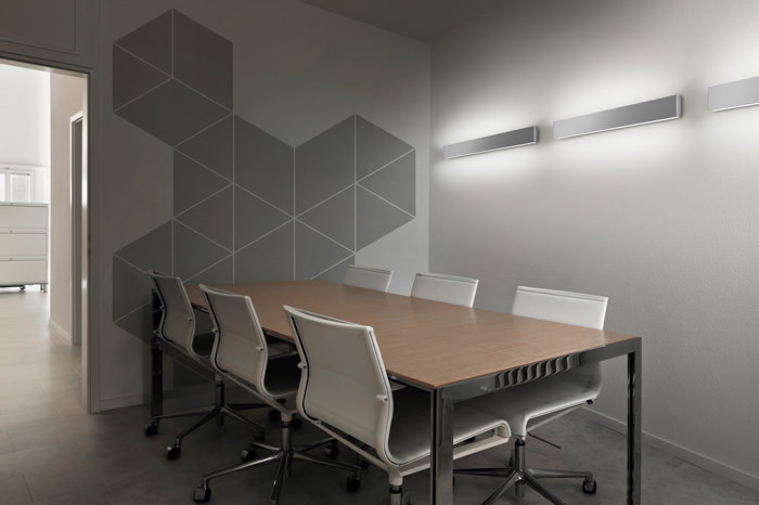 Modern conference room with wooden table and ergonomic chairs.