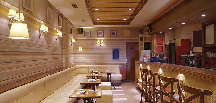 Cozy wooden interior of a small restaurant with warm lighting and simple seating.