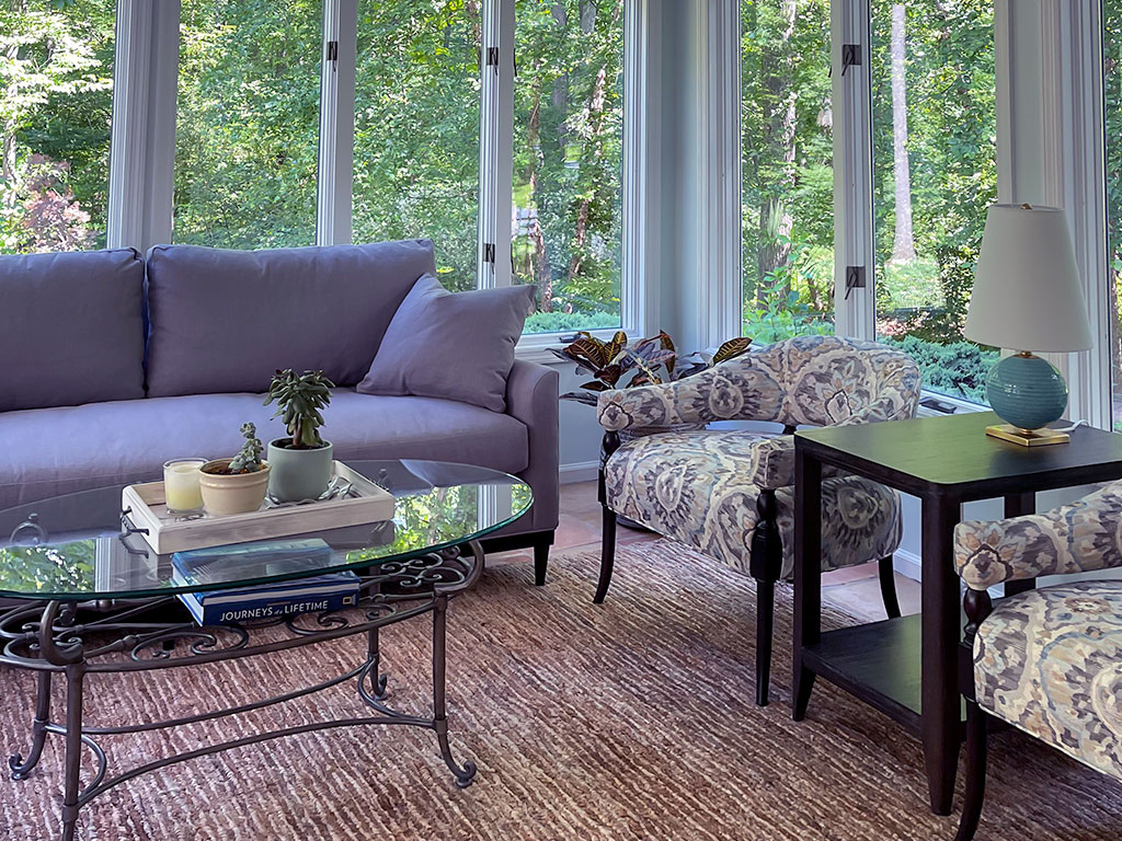 Cozy living room with a purple sofa and glass coffee table.
