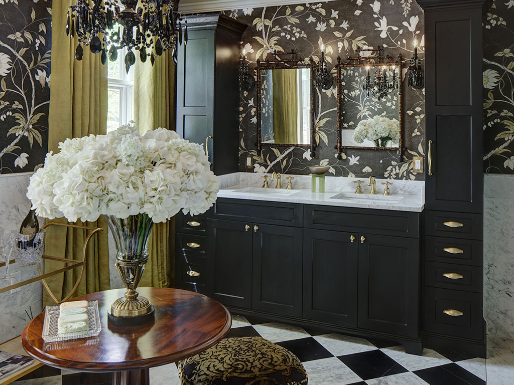 Elegant bathroom with black cabinetry and floral wallpaper.