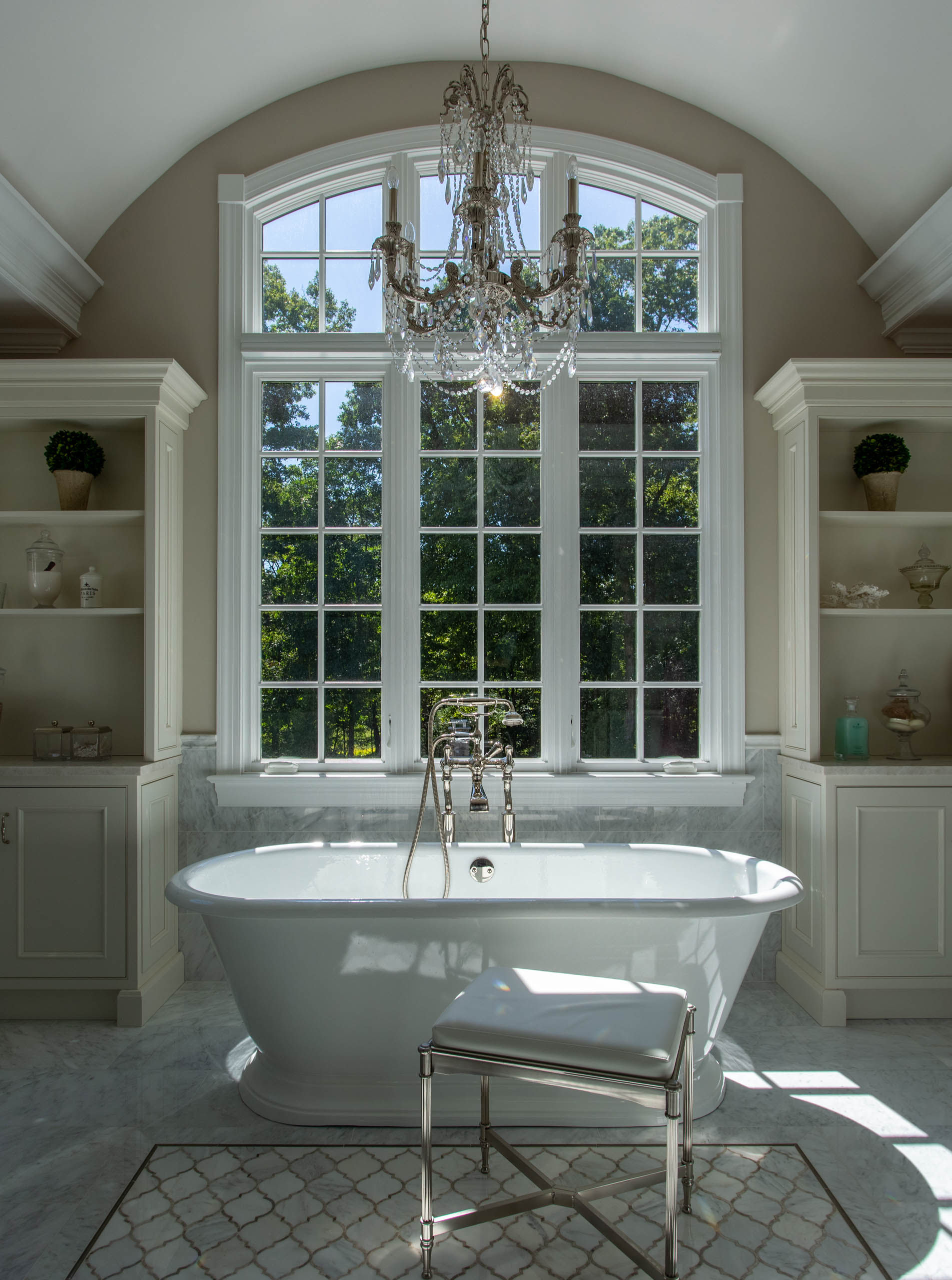 Bright and elegant bathroom with a freestanding tub and large window.