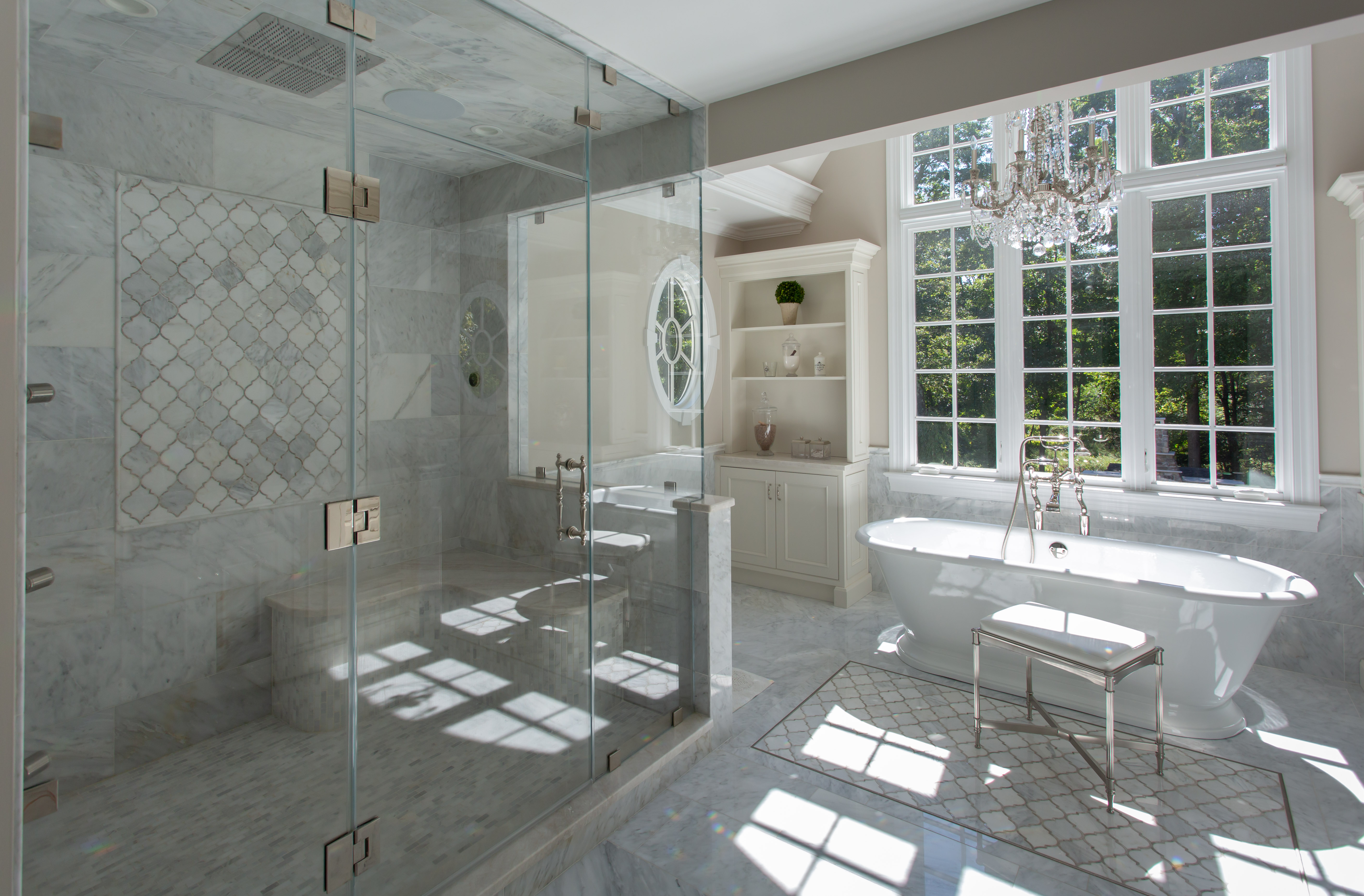 Luxurious marble bathroom with glass shower and freestanding tub.