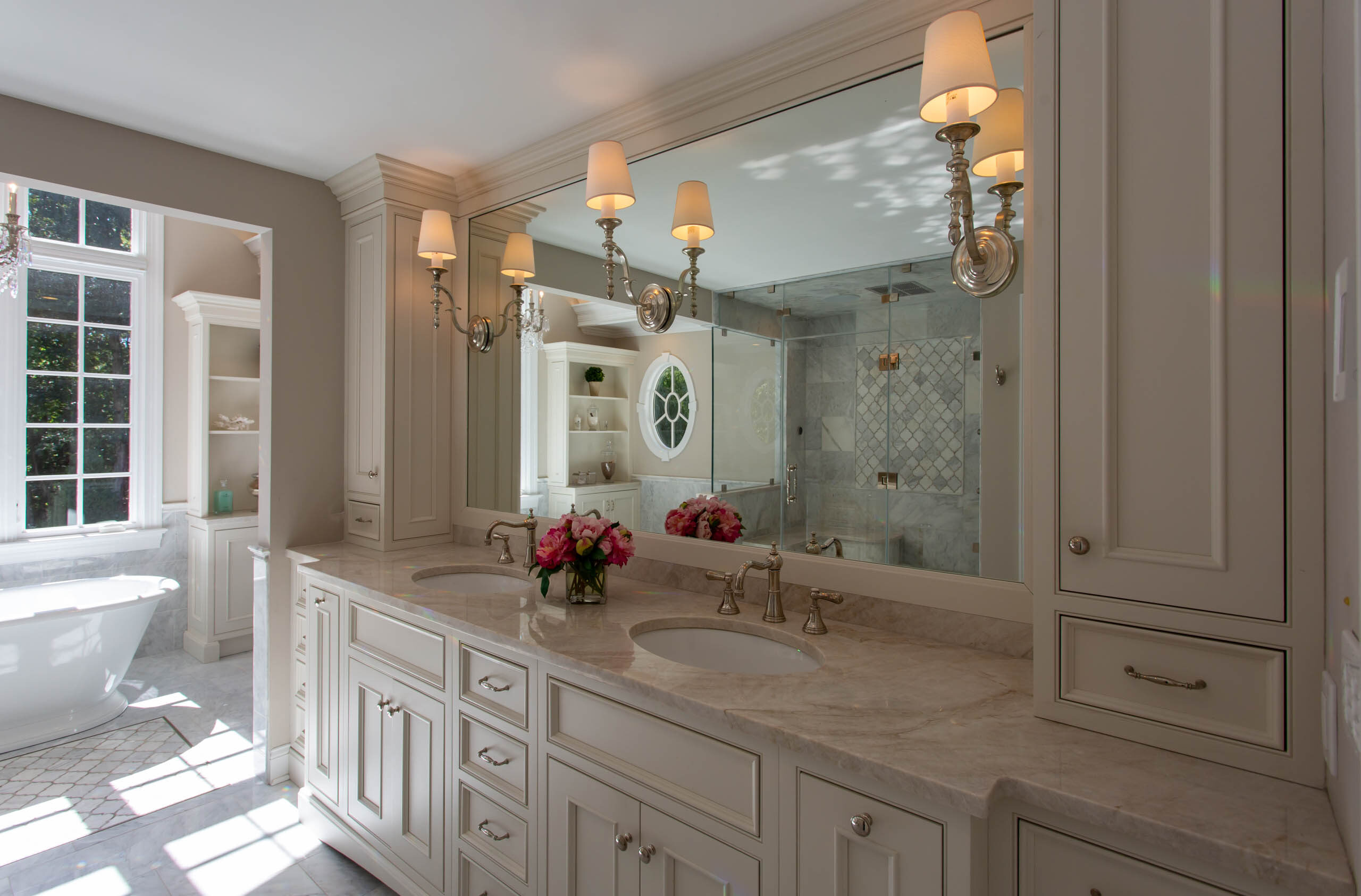 Elegant bathroom with marble countertops and dual sinks under soft lighting.
